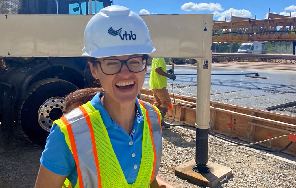 Olivia Richards in a VHB hard hat and safety vest, laughing at the camera