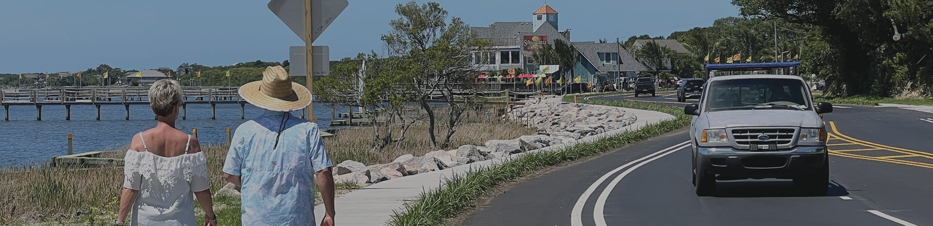 Two people walk along the new sidewalk at the completion of the project.