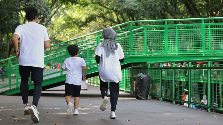 A Muslim family jogging in a park