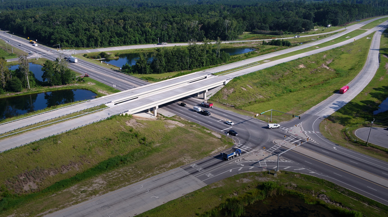 Aerial view of a busy highway interchange with semitrucks.