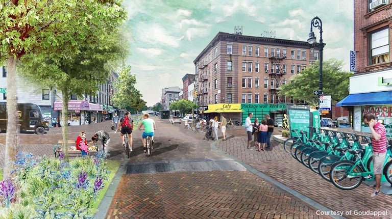 A downtown area with pedestrians an bicyclists enjoying the day.