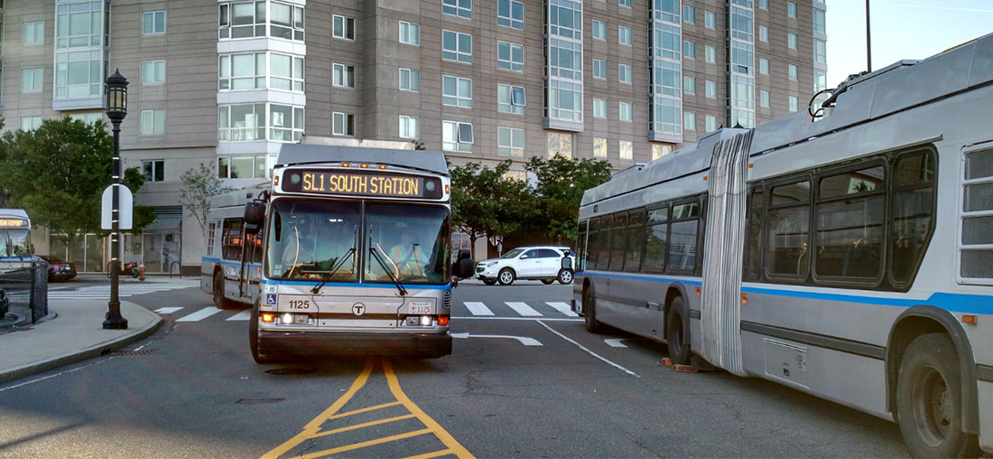 Several Silverline buses traveling city streets of Boston.