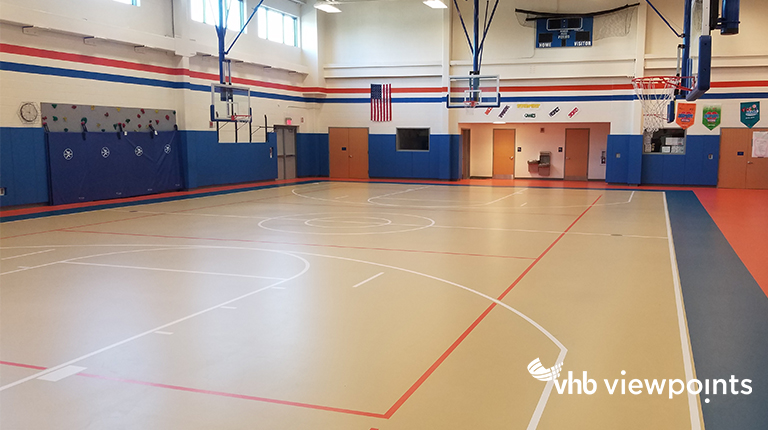 Gymnasium with multi-colored floor and blue, padded walls.